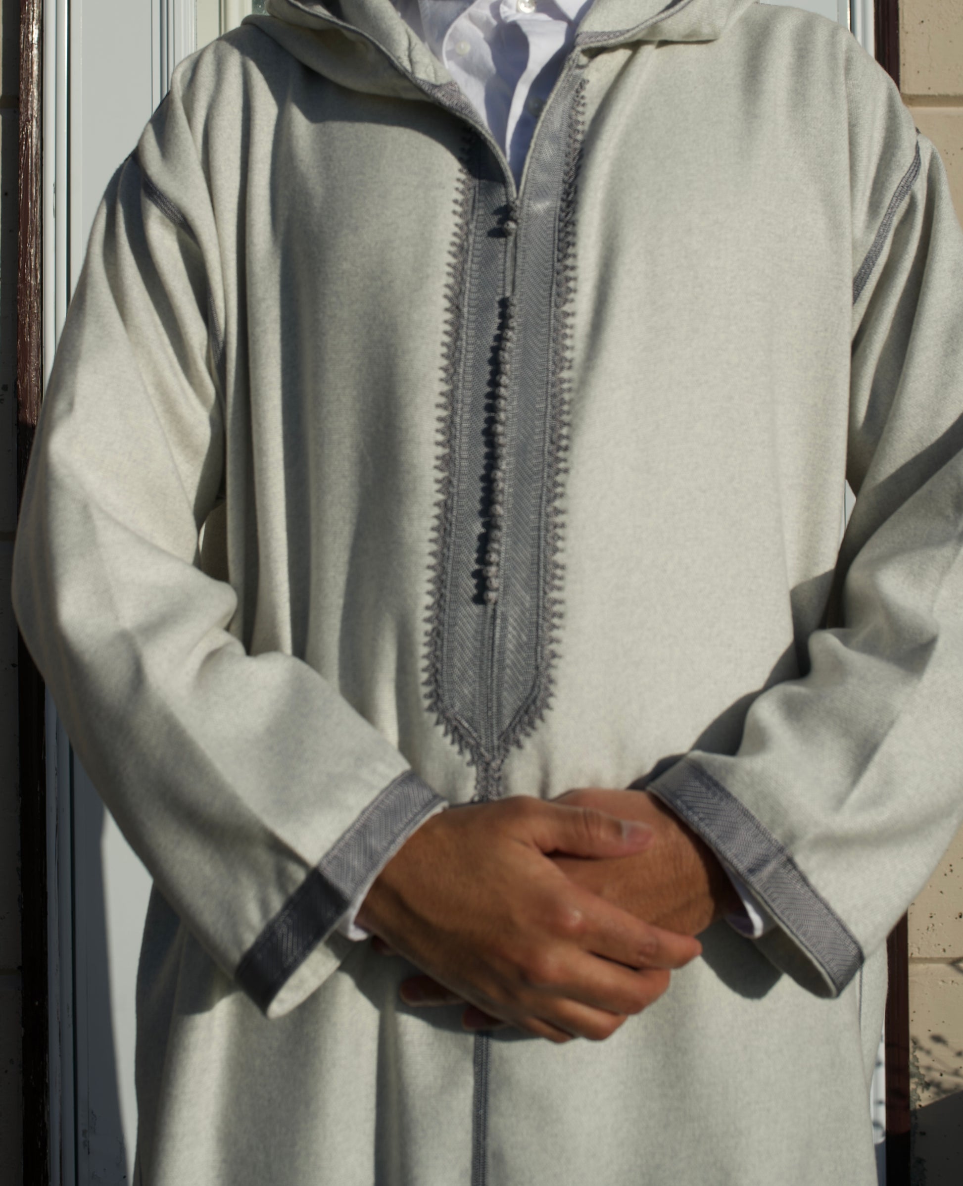Light gray traditional garment with a zipper detail on a neutral background