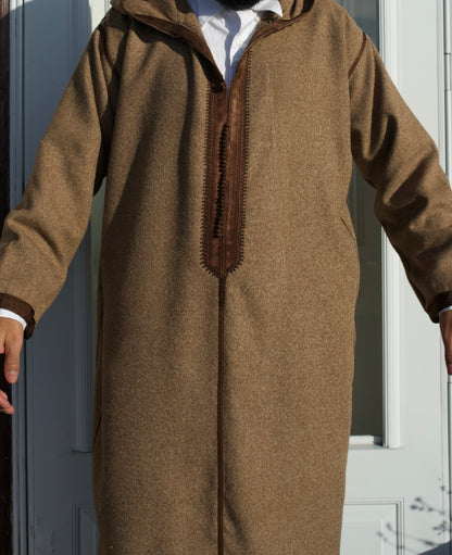 Brown hooded garment worn by a person against a neutral background
