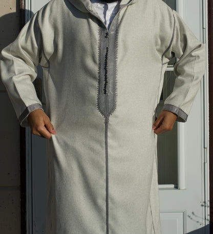 Person wearing a light gray traditional outfit with a zipper detail, standing against a neutral background.