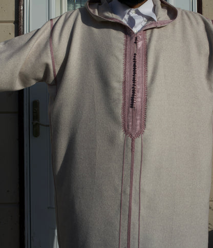Beige long-sleeve shirt with decorative stitching on a plain background