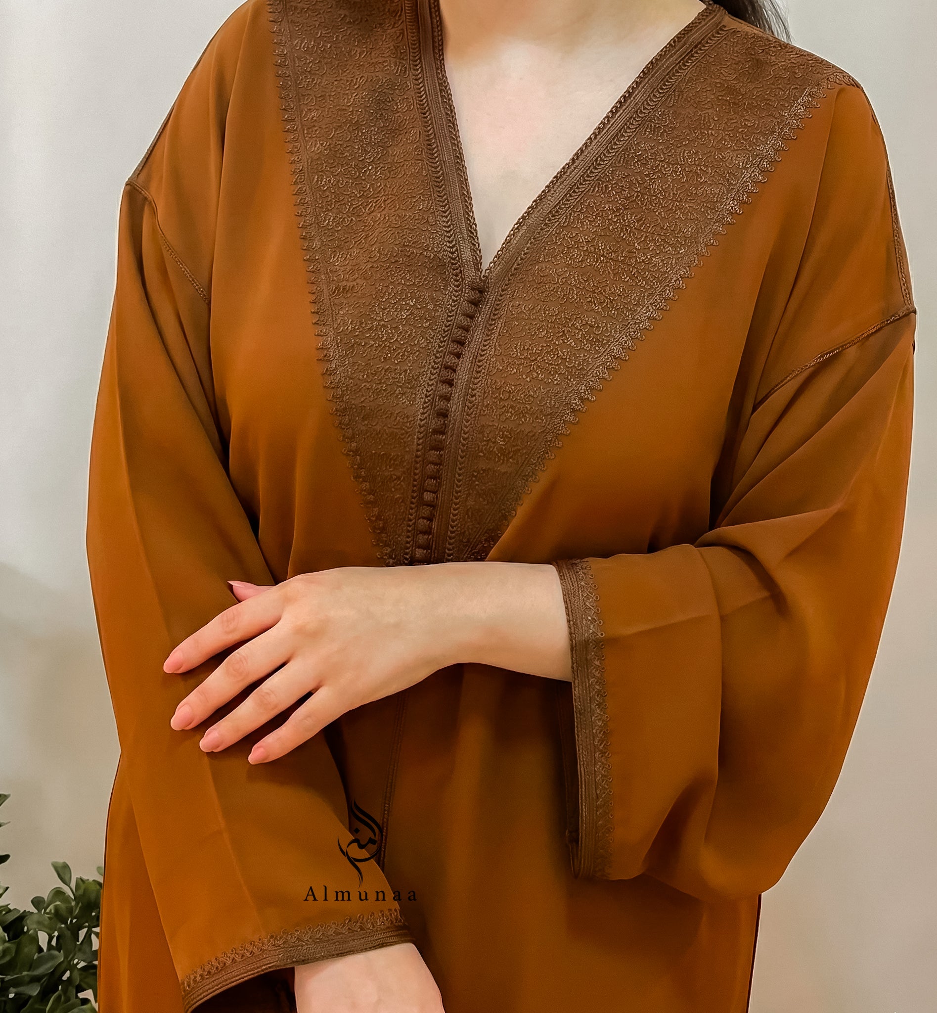 Brown garment with embroidered details on a neutral background