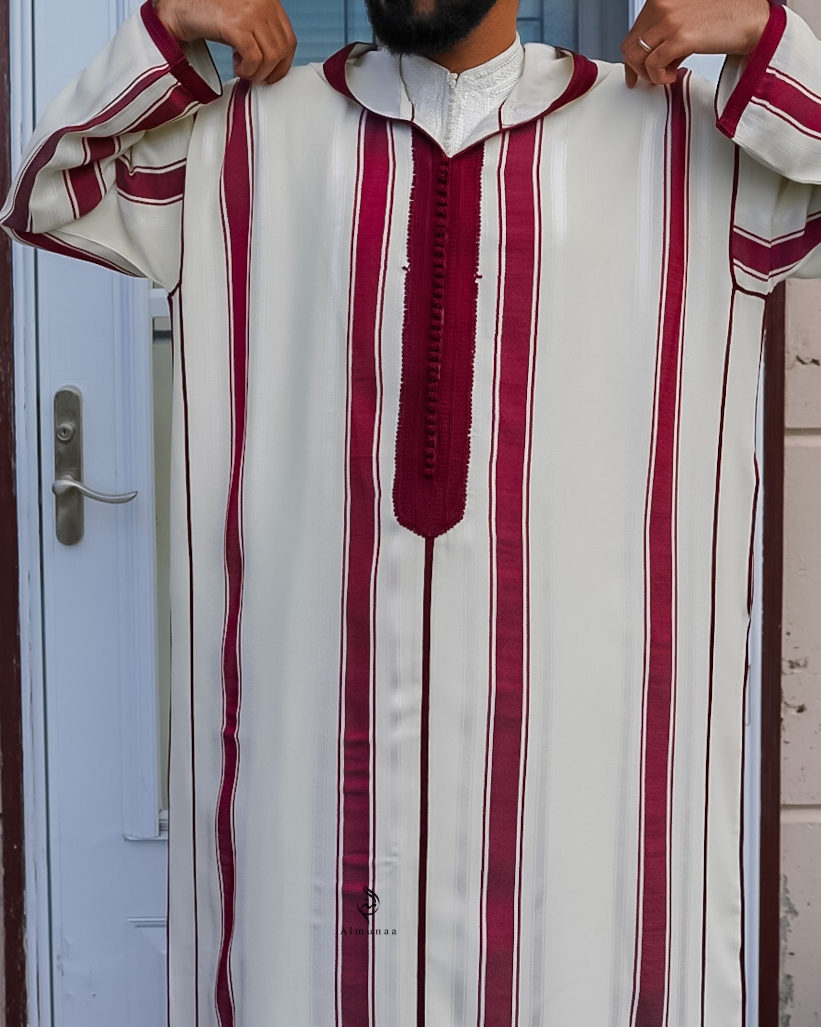 Person wearing a white and red striped garment with a decorative collar.
