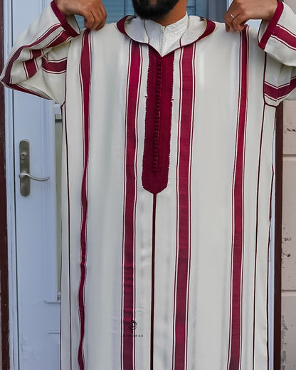 Person wearing a white and red striped garment with a decorative collar.