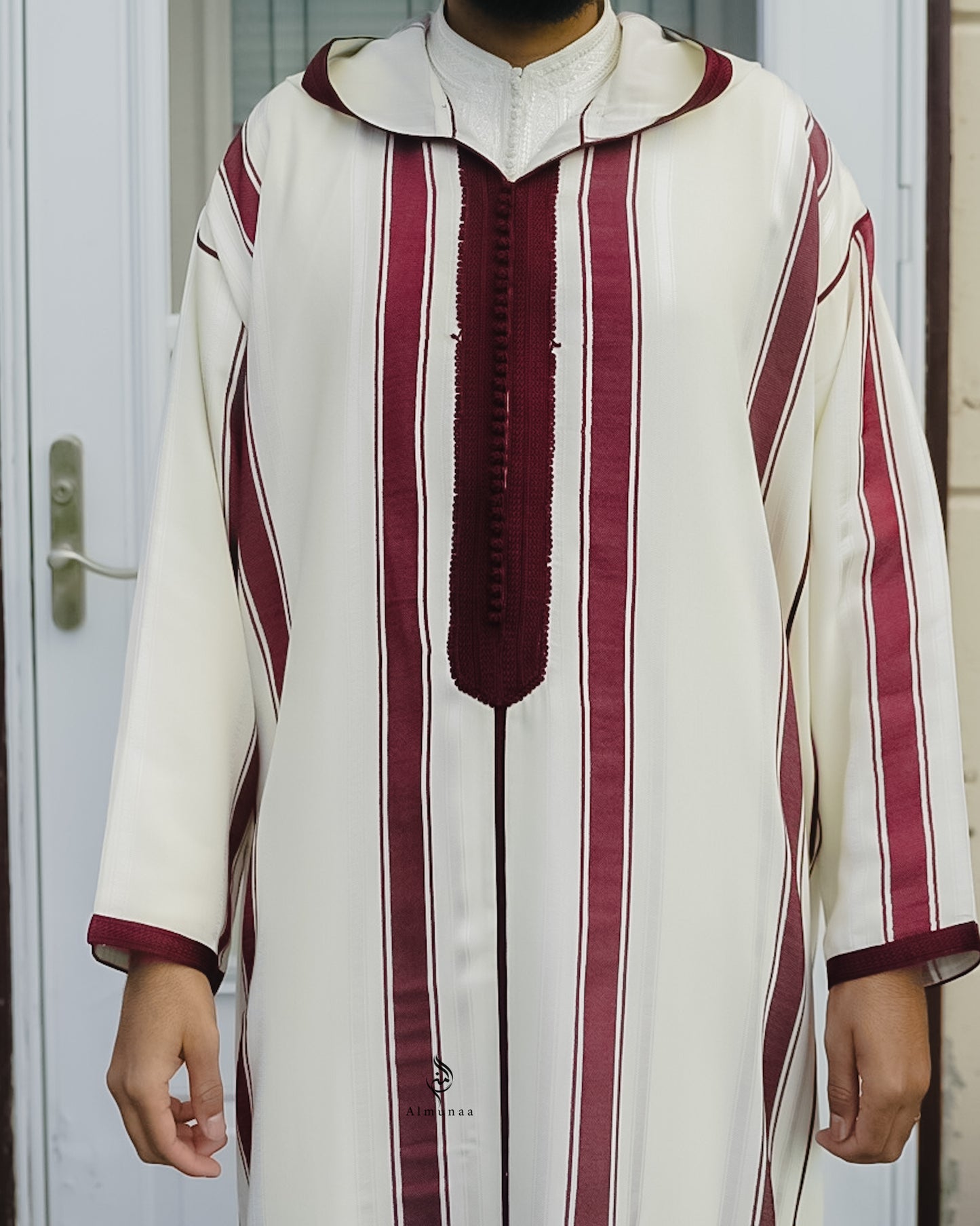 Person wearing a traditional outfit with white and maroon stripes.