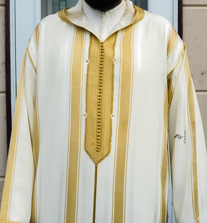 White garment with gold stripes and a zipper, featuring the brand 'Almanar'.