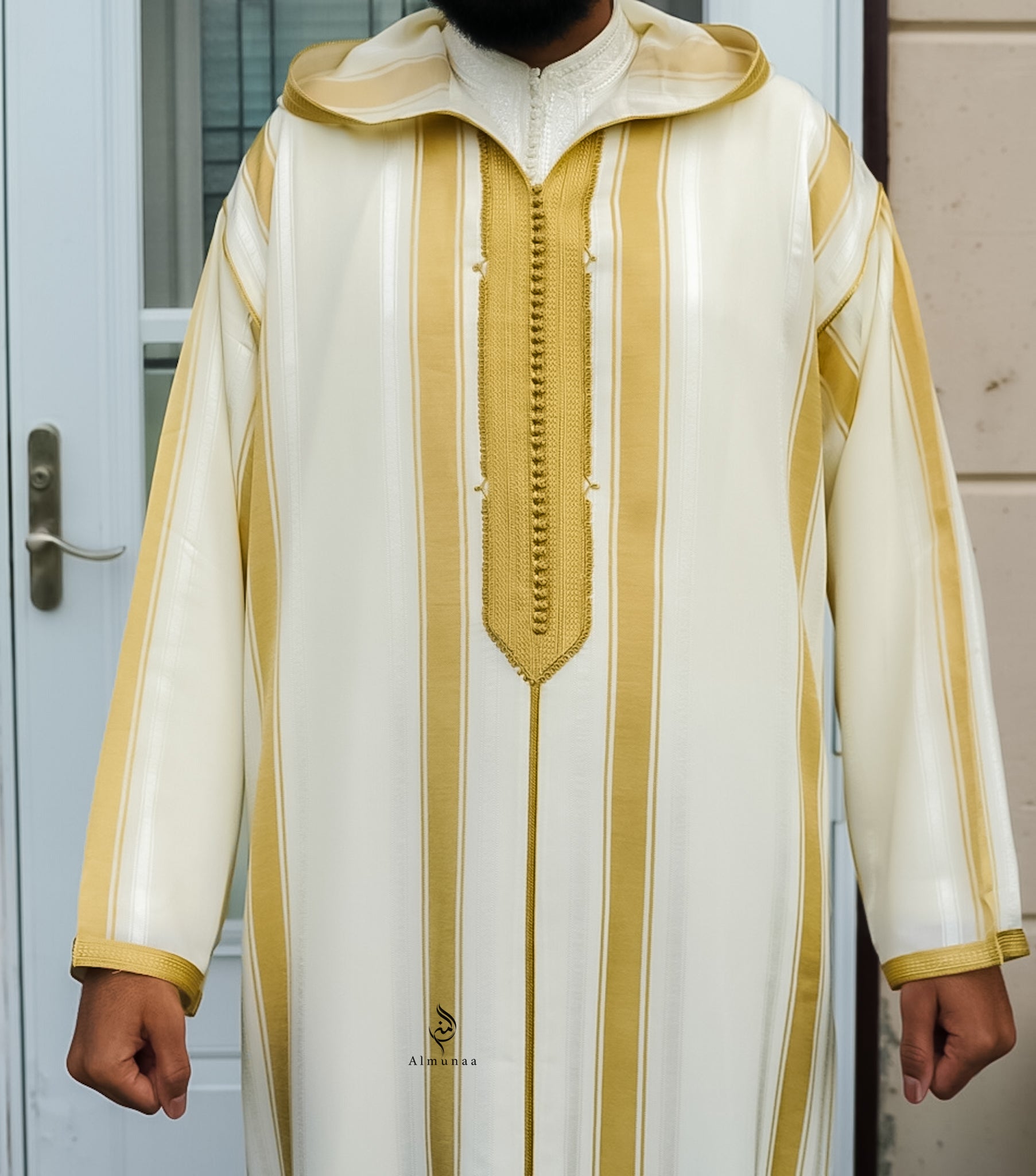 Traditional white and gold garment with intricate design, worn by a person.
