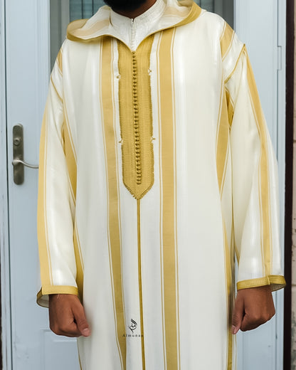White and gold traditional outfit worn by a person against a light blue door.